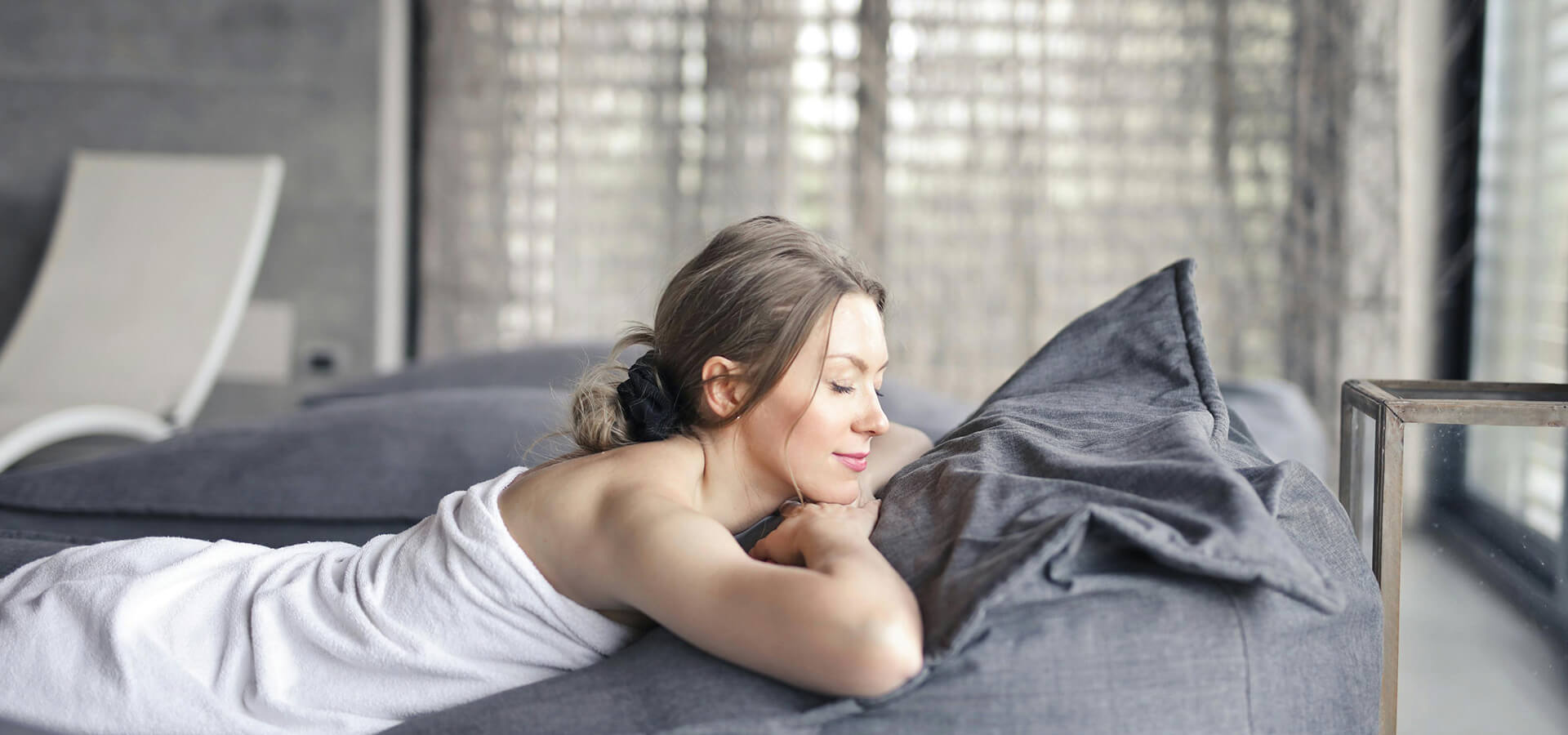 Mujer relajándose en camilla de spa.